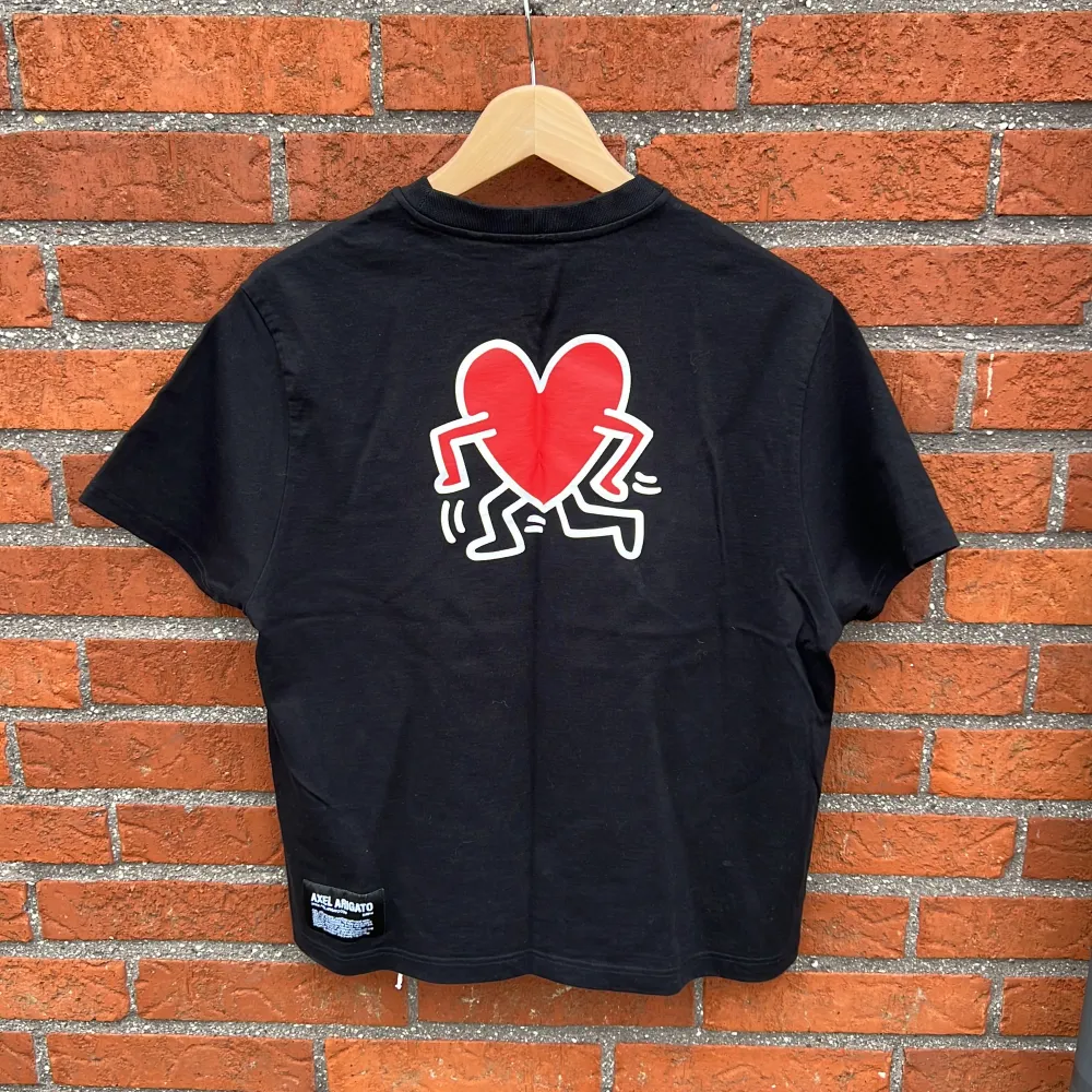 Skitsnygg designer t-shirt av Keith Haring & Axel Arigato, perfekt inför sommaren! Sparsamt använd o i bästa skick. Nypris ca. 900kr !(Kan kombineras i ”paket” med samma modell i vitt)!. T-shirts.