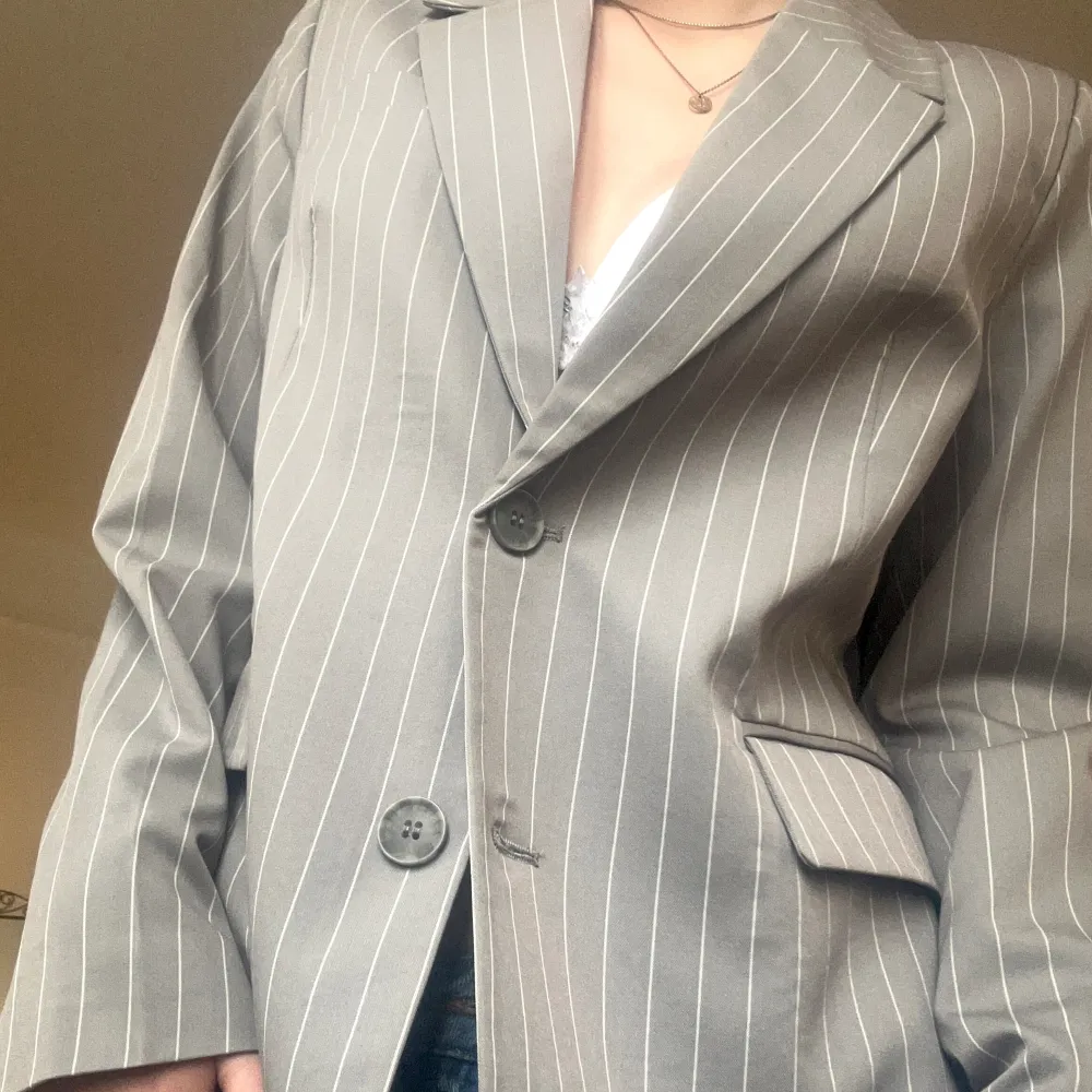 En superfin oversized kavajmed axelvaddering i en härlig grå färg från Bik Bok!💗 Endast använd en gång, så som ny. Väldigt fin knäppt med en spetstopp under och en kort kjol!! Pris är prutbart!!🙌(sitter bra på mig som S men funkar säkert till M). Kostymer.