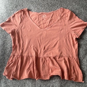 T-shirt med volanger - T-shirt med volanger! Sitter jättefint och har mycket skönt material! Köparen står för frakten!