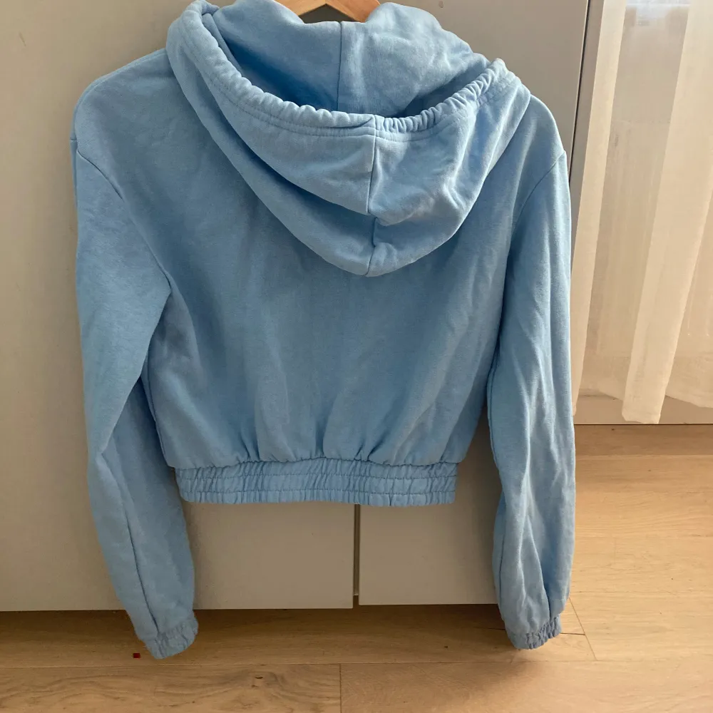 En blå croppad hoodie med dragkedja från HM divided i storlek xxs. Använd men i bra skick😊. Hoodies.