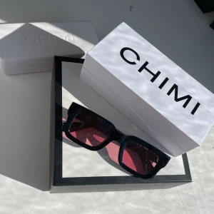 Chimi 05 rosa - Ett par fräcka chimi 05, svarta med rosa glas!! Bra skick, inga repor eller dylikt. Kartong och fodral medkommer!!☺️☀️