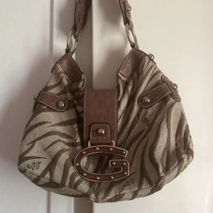Guess väska  - superfin handväska från guess, vet inte om den är äkta därav priset. trasig i ytterfacket. 💕