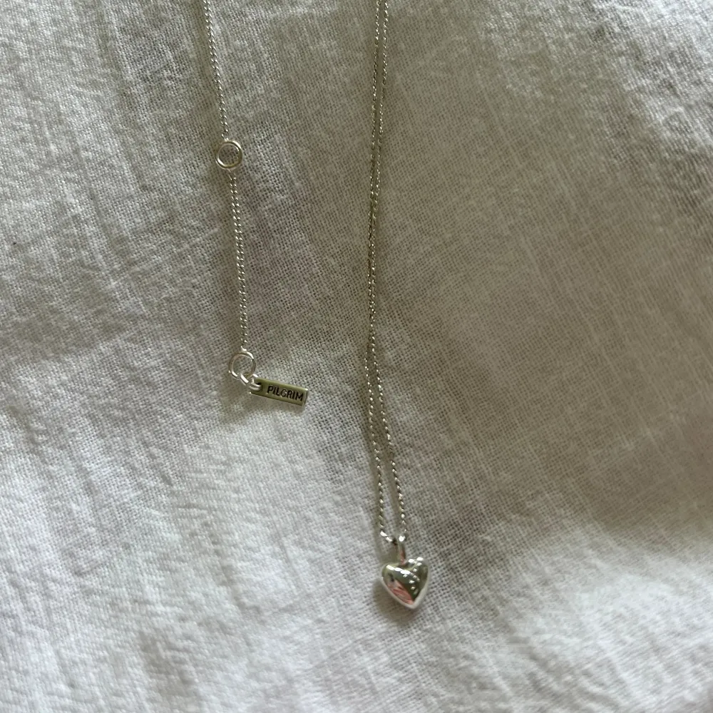 Silver halsband från pilgrim med ett mindre hjärta med mönster i💗 längden är reglerbar.. Accessoarer.
