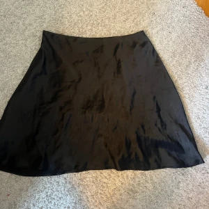 Svart satin kjol - Satin kjol från chiquelle. Använd fåtal gånger, därav ny skick!