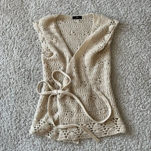 Kortärmad kofta  - Skickad väst/kortärmad kofta som man knyter i midjan