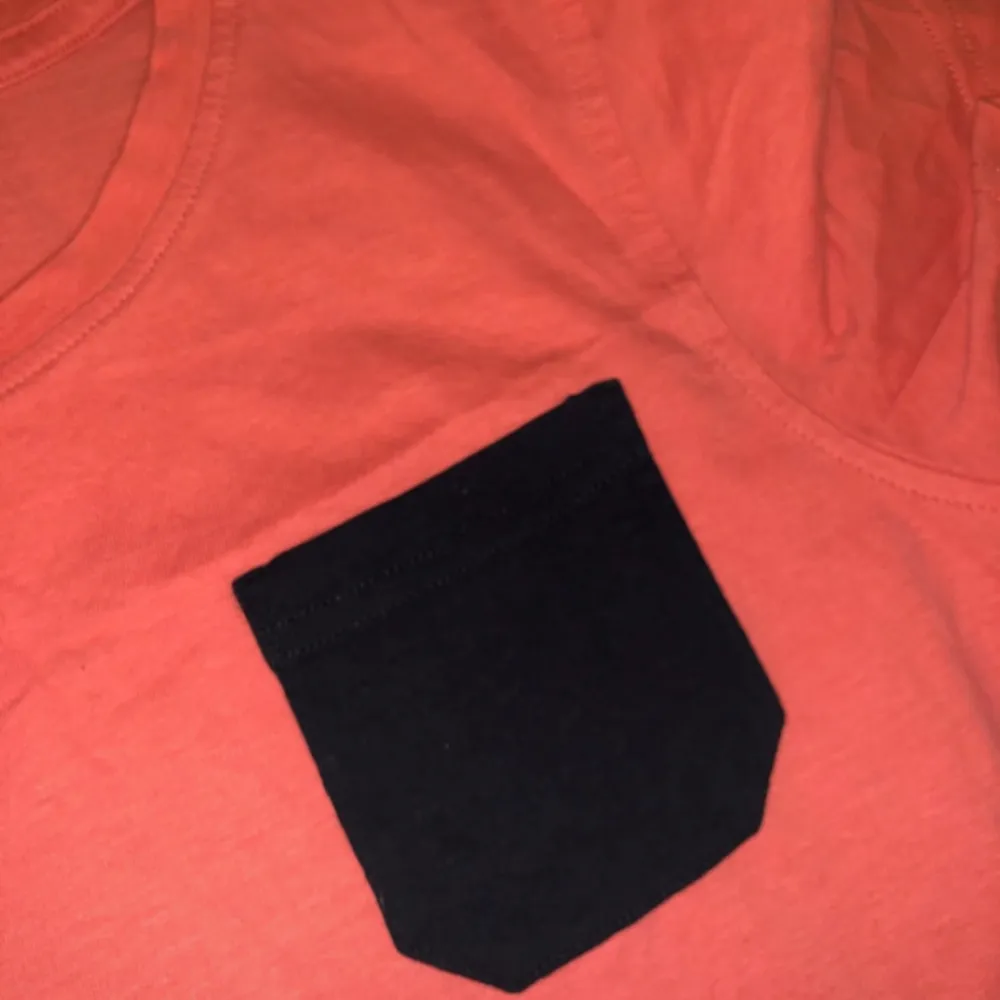Coral red t-shirt with a navy pocket . T-shirts.