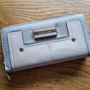 Plånbok från River Island  - Ljusgråa plånboken från River Island i bra skick inga skador 