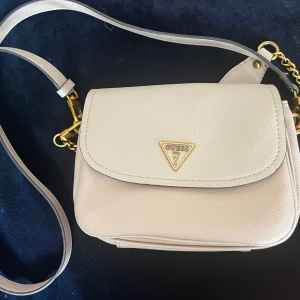 Guess väska  - Superfin handväska från guess.  Det enda jag kan hitta som är att påpeka är lite skav runt magnetlåset under locket, det syns inte vid användning. Samt att det syns i fodret att väskan är använd.  Mycket rymlig trots sin storlek