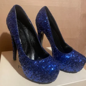 Blå glittriga klackskor - Glittriga Blåa klackskor.  Högklack, endast testade. Storlek 38