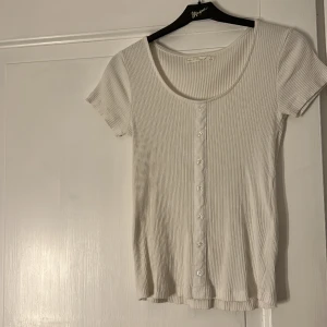 Vit T-Shirt med detalj!  - Säljer denna vita tröja köpt från Ullared för något år sen eller två! Inte fått någon användning av den, så tänker att någon annan kanske hade haft användning av den!  Storlek S Nypris: 79 :- Säljer för: 20 :- 