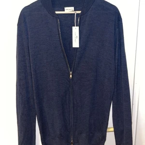 John Henric zip  - Säljer nu en helt oanvänd John Henric zip. Riktigt snygg och och stilig. Prislappen och allt sitter kvar på. Hör av er vid frågor.