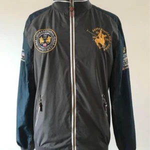 Jacka Santa Monica Polo Club Strl S  - Modellen heter Milford Strl S Tyget på kroppen är grått och på ärmarna blått Nypris 350:- Mitt pris 200:- Mycket fint skick   Finns på Ekerö  Kan möta upp i Sundbyberg  Skickar gärna 