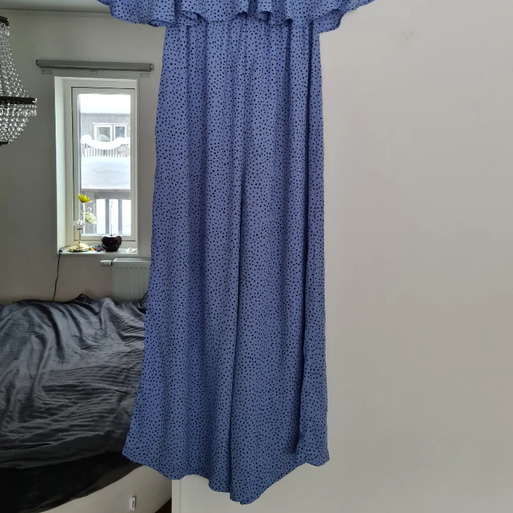 Blå jumpsuit med svarta prickar, offshoulder med volanger. Härlig och lättsam att ha en varm sommardag. Använd 1 gång. Normal i storleken. Kom med prisförslag 😊  Material: 100% Polyester. . Övrigt.