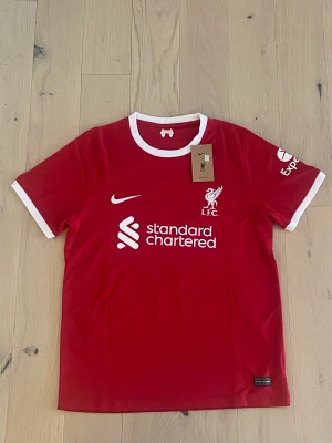 Liverpool 23/24 kit - Liverpool 23/24 matchställ  Szoboszlai Säljer den oanvänd, lappen är kvar då den va förliten, kan bli billigare vid snabb och smidig affär.