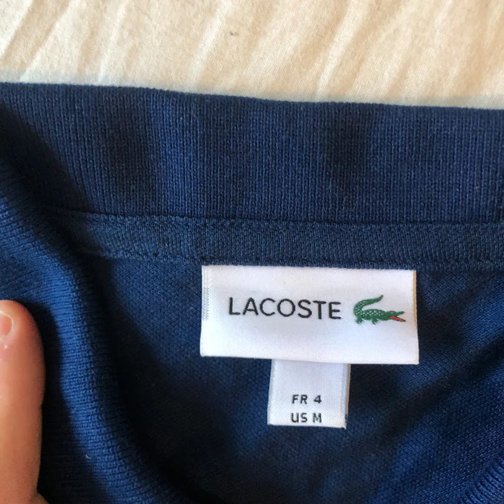 Polo Lacoste, i mycket gott skick, färg mörkblå, size L. T-shirts.