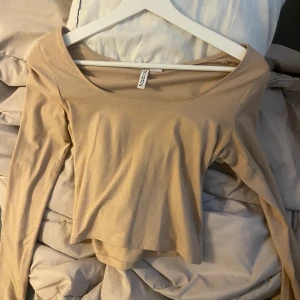 Beige tröja med slits  - Slits vid ärmen, varm beige färg använd några gånger alltså har den noppror på sig 