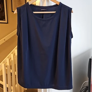 Linne i polyester - Nästan oanvänt, bra skick  mått axel till axel 42 cm, längd 61cm