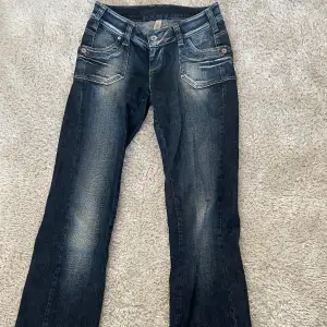 Säljer dessa supersnygga y2k jeans som är köpta secondhand! De sitter jättesnyggt och märket är Vero Moda. Midjemått tvärsöver är 35cm och innerbenslängd är 75cm. De är lite slitna men fortfarande bra skick! Skriv för fler bilder eller vid frågor!😊