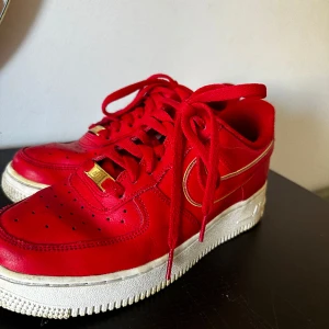 Röda Nike Air Force  - Använt skorna några gånger Röda med gulddetaljer  Storlek 39