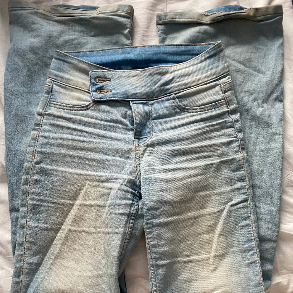 Supersnygga jeans med ett ”bälte” i midjan💋 ljusblå och flared. Som ni kan se på andra bilden är det små hål längst ner på benen men kan lätt lagas. Annars är dom faktiskt väldigt små så man tänker inte på det❤️älskarrr!! Köpppp. Jeans & Byxor.