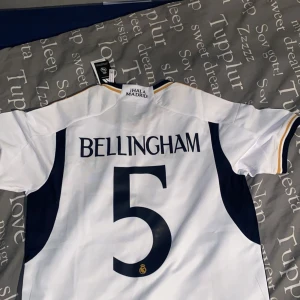 Real Madrid Bellingham  - Hej säljer denna helt oanvända realmadrid tröjan pågrund att den ej var i min storlek. Den är äkta och det står även Bellingham på ryggen. Hör av er vid frågor om pris och frågor.