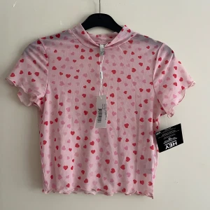 Hjärtan top🩷 - Mesh-Top från Nelly i storlek S. Aldrig använd. Köparen står för frakten men kan mötas i Kalmar. 