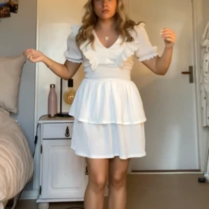 Vit volang klänning  - En vit volang klänning från Gina Tricot, helt ny och lappar finns kvar, var tänkt till student men blev inte så. Köpt för 399kr❣️