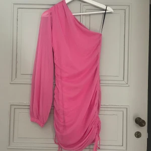 Offshoulder klänning - Säljer denna klänning! Så fin med en långarmad arm och ena bar! Den ger en extra touch med att den är skrynklig längst ner! Aldrig använd! 🩷💞