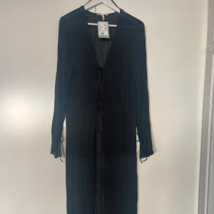 H&M Edition- krinklad lång blus med knyt. Strl M - H&M Edition- oanvänd lång blus i krinklat material med knyt.  Jätte snygg på men fel storlek för mig.  Strl M.  Nypris 349:-