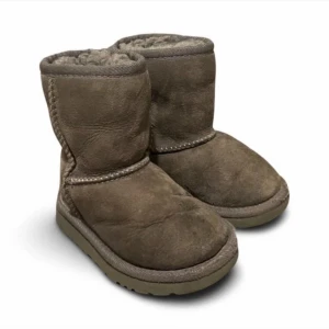 Riktiga ugg UGGS grå för barn i storlek 23 - Här är chansen att skämma bort ditt lilla hjärta med riktiga uggs i en grå färg! Dessa gosiga stövlar är perfekta för barn i storlek 23 och kommer inte bara hålla deras små fötter varma under kalla dagar, utan också göra dem till de coolaste trendset