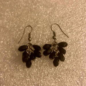 Mindre svarta örhängen  - Använda enstaka gång. Okänt material. Inget att anmärka på.
