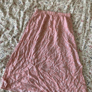 Kjol - En rosa kjol från lager 157 med vita blommor på. Fickor . Nyskick 