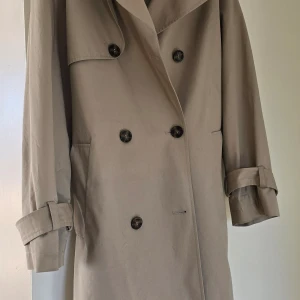 Trenchcoat- Beige  - Hej!  Välbevarad trenchcoat i beige färg.  100 procent bomull utsida. Tyget är "stelt", så kragen är lätt att forma.  Storlek x-small/small. Jag är medium och den sitter bra på mig. Använd 2-3 gånger, så den är som ny!! Inga anmärkningar! 