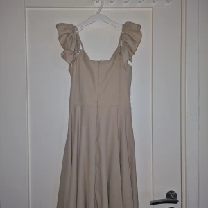 Beige Klänning med Knut - Säljer min mammas klänningar. Säljer denna beiga klänning med knut på baksidan. Storleken är 38. Säljer den för 199:-