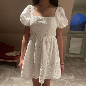 Vit sommarklänning  - Säljer denna helt otroliga klänningen som är öppen i ryggen med söta broderier som är perfekt nu inför midsommar men även annat. Så söt men säljer då den inte kommer till användning.