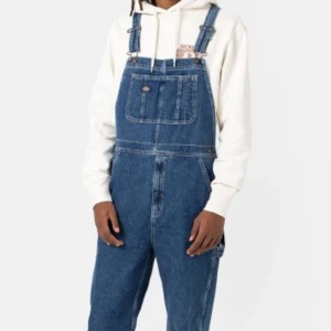 Dickies hängselbyxor herr - Jeans hängselbyxor med straight leg modell, mörkblå och använd endast vid tillfället två av dessa bilder tagits, ena bilden är tagen från Dickies hemsida själv för klarhet. Perfekt skick, köpte för 1099kr. Personen på bilden där byxan bär på är 190cm