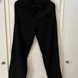 Snygga svarta kostymbyxor med vita tunna ränder. Använda flertal gånger men är i nyskick.