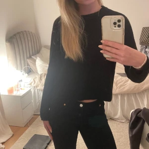 Svart stickad tröja - En svart stickad tröja som inte är jätte tjock, den är också ganska kort så den är jätte snygg till lågmidjade jeans