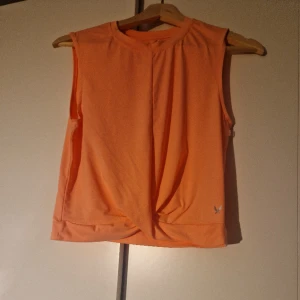 En orange träningströja - En oanvänd träningströja från Stadium. Den har en fin knut vid magen 