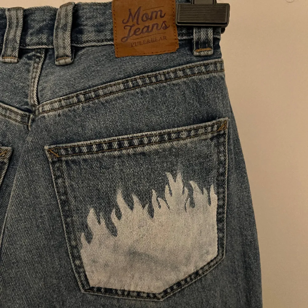 Mom jeans köpta från pull & bear med vita flammor på ena bakfickan. Endast använda ca 3 gånger men de matchar inte min längd men de ser jätte bra ut när de sitter rätt. Orginalpris 299kr. Jeans & Byxor.