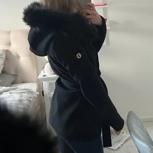 Svart kappa - Säljer denna kappan med fakepäls från Hollies Stockholm💓man kan ta av pälsen runt luvan. Knappt använt, samma skick som en ny!❤️Nypris 1700kr❤️kom privat för fler bilder! (pris kan diskuteras vid snabb affär) 