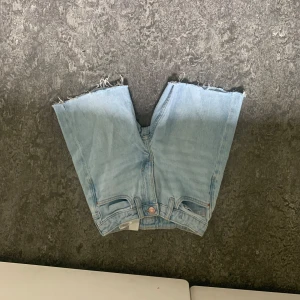 Ljusblå jeansshorts - Ett par ljusblå jeansshorts med råa kanter. Shortsen har en klassisk femficksdesign och är tillverkade i denim.