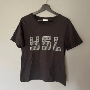 Saint Laurent YSL flag tee - T-shirt från Saint Laurent (2017) i väldigt bra skick. Passar tts small. Hör av er för frågor eller fler bilder!