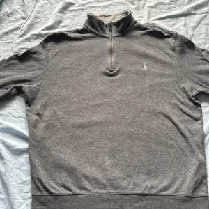 Ralph lauren tröja - En snygg grå Ralph lauren tröja med krage som går vika ner. Den är andvänd men i ett gott skick. Storlek 170 Nypris 1400 