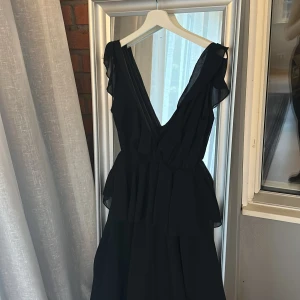 Svart långklänning med volanger - Sååå fin svart långklänning med volanger från boohoo!! Perfekt till lite finare tillställning🥰 Jag betalade 630kr på rean, så passa på nu😅Den är aldrig använd, bara provad! 