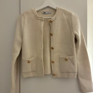 Stickad kofta - Vit skickad kofta med guldetaljer ifrån Zara. Använd 1 gång