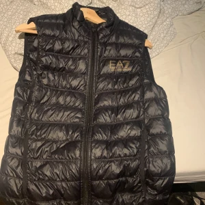 EA7 Armani väst - Emporio Armani väst. Jag säljer den för jag har ingen användning till den och den har blivit använd ett fåtal gånger. Kan säljas för billigt pågrund av att jag behöver bli av med den. Kan frakta och mötas 