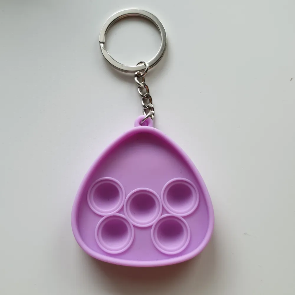 Pop-it/fidget toys nyckelring Färg: lila Form: valros Skick: oanvända. Ej lämpliga för barn under 3år. Då det innehåller smådelar. Asusteet.