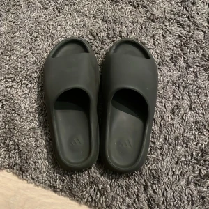 yeezy slides - yeezy slides som jag nu säljer då jag har skaffat andra tofflor, extremt bra kvalitet och jätte sköna att arbeta i då dom är mjuka och har en bra dämpning, storlek 11 us men passar mig med 42,5 i skostorlek, ingen box tyvärr, kom med frågor eller bud