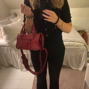 Röd väska - säljer min balenciagaliknande väska (inte äkta), den är använd men fortfarande i väldigt bra skick. den rymmer mycket, justerbara axelband☺️öppen för byten mot en likadan svart